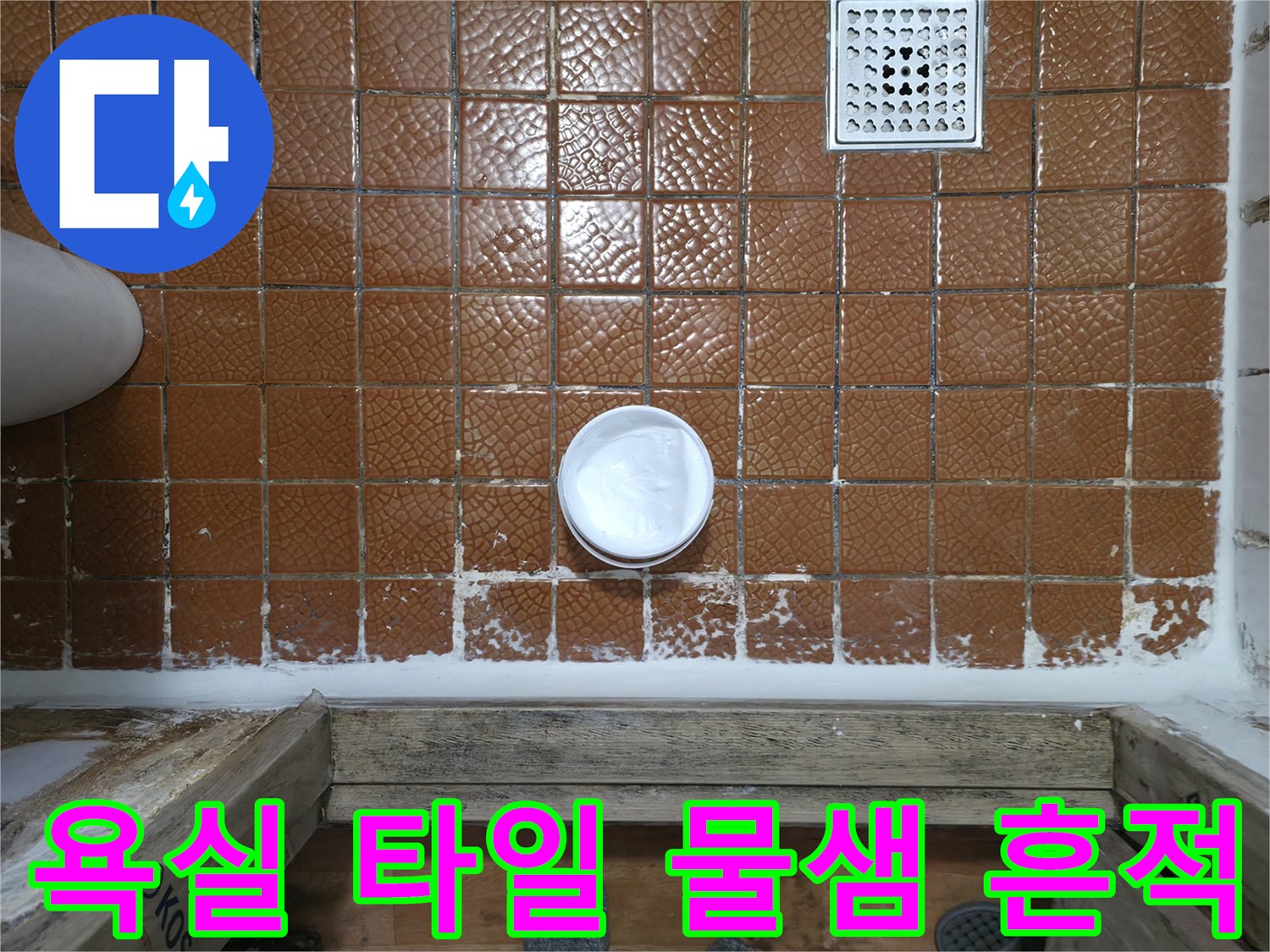 갈색 타일과 흰색 배수구 주변의 젖은 상태
