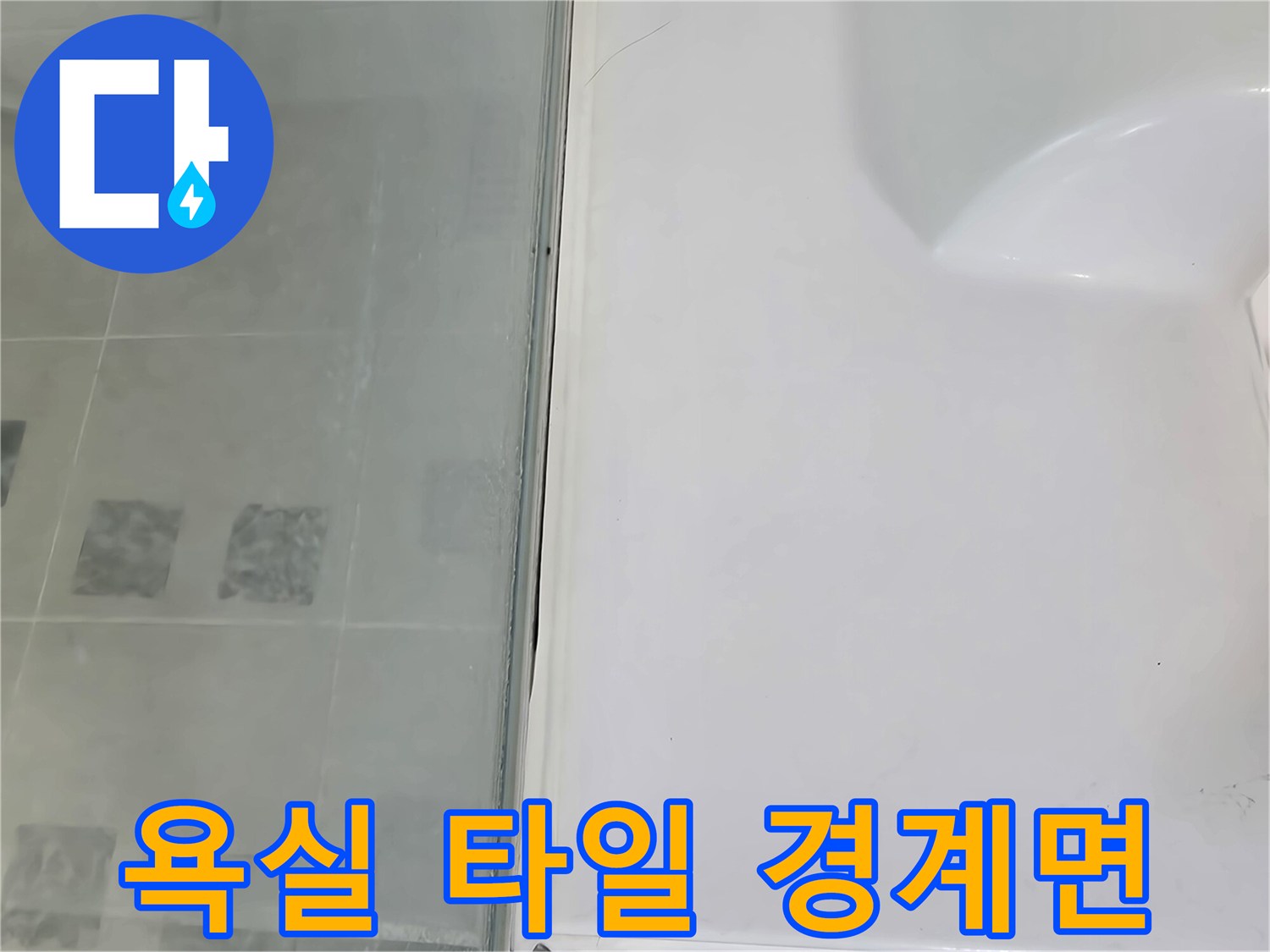 하얀색 욕조 테두리와 회색 타일이 맞닿은 접합부 모습