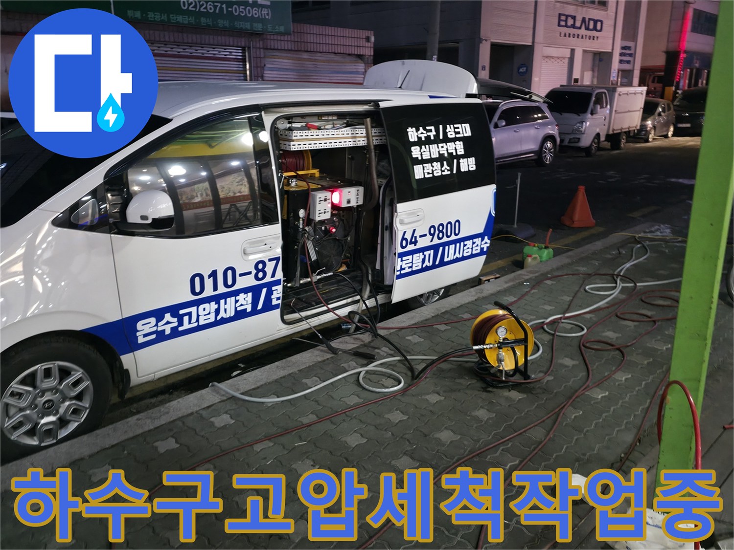 차량에 장착된 고압 세척기와 호스를 연결하여 상가 하수구를 청소함