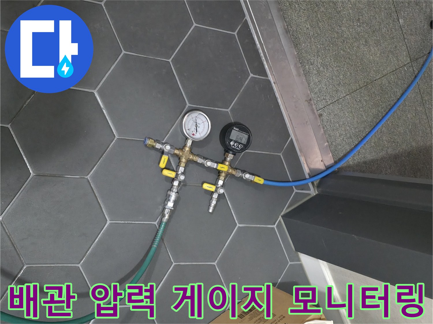 타일 바닥의 배관 분기 장치와 연결된 호스들