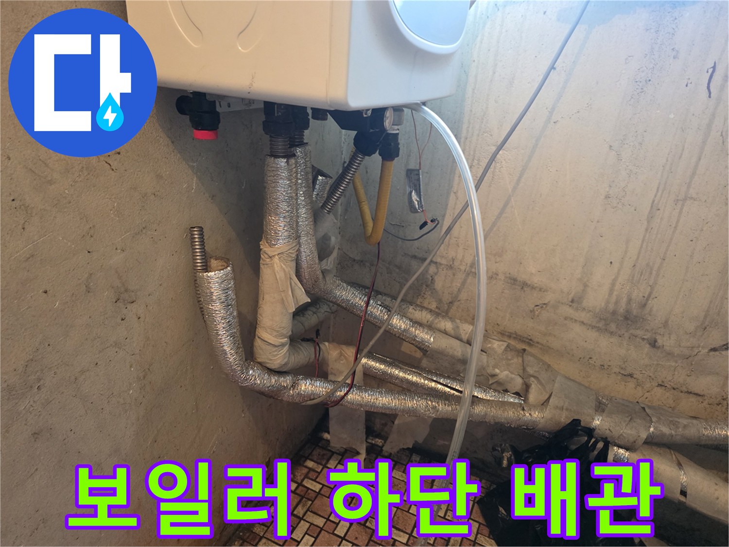 보일러 본체 아래 연결된 은색 보온재 배관들