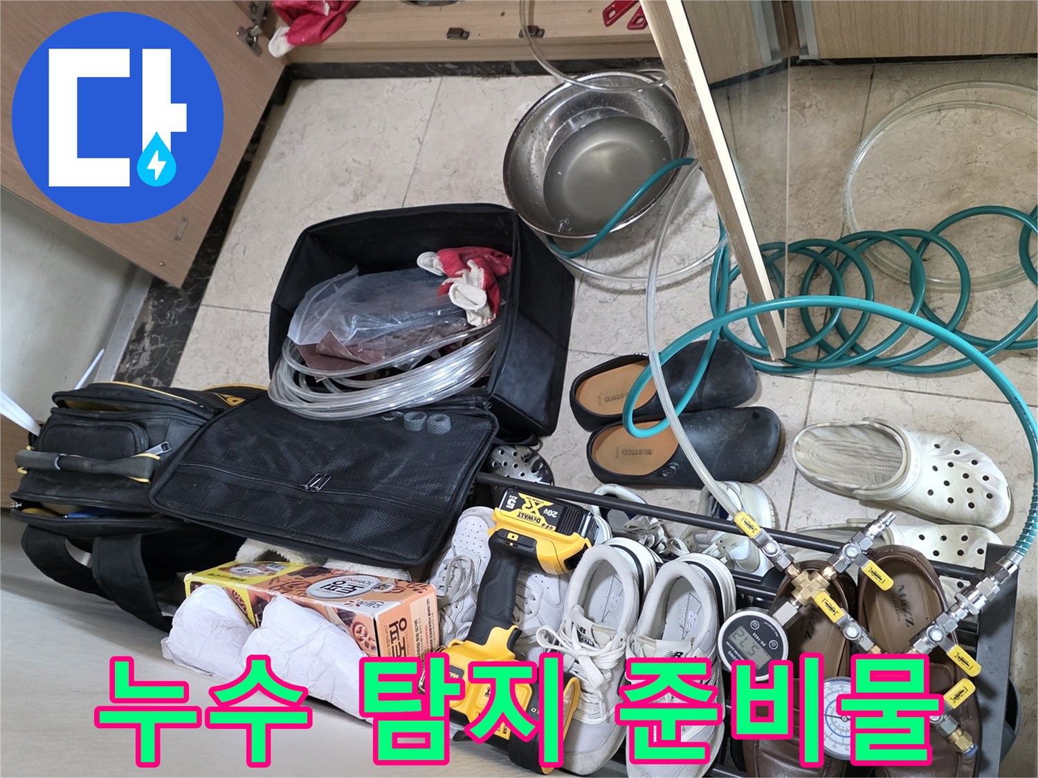 배관 수리를 위해 싱크대 밑에 배치한 압력계와 보조 도구들