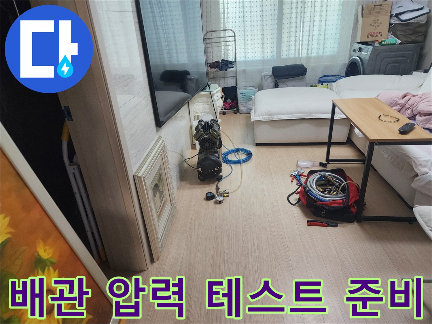 거실 공간에 배치된 누수 탐지용 공압 장비와 호스 뭉치