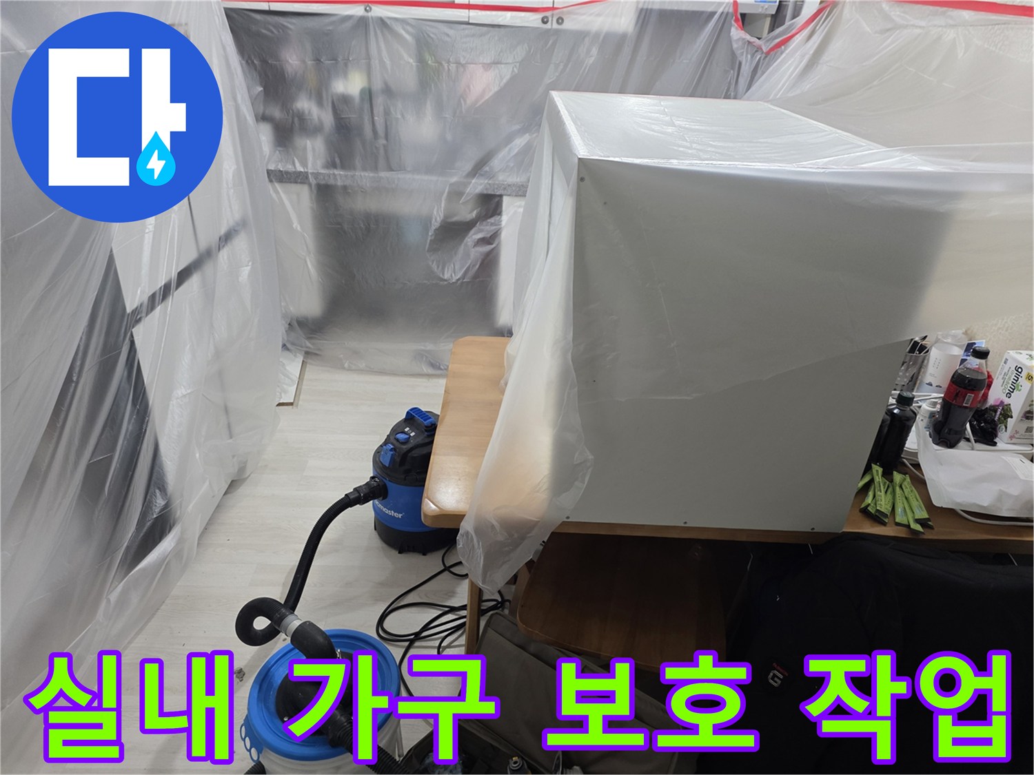 공사 중 먼지가 쌓이지 않도록 가구를 비닐로 감싸놓은 현장 사진입니다.