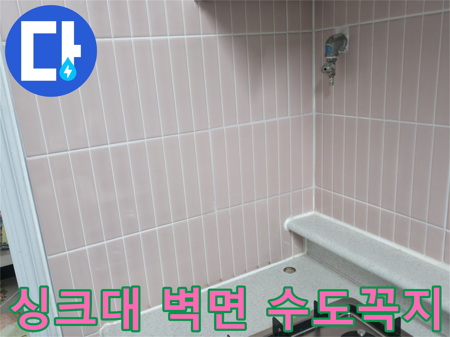 분홍색 세로 타일이 시공된 벽면에 설치된 수전입니다.