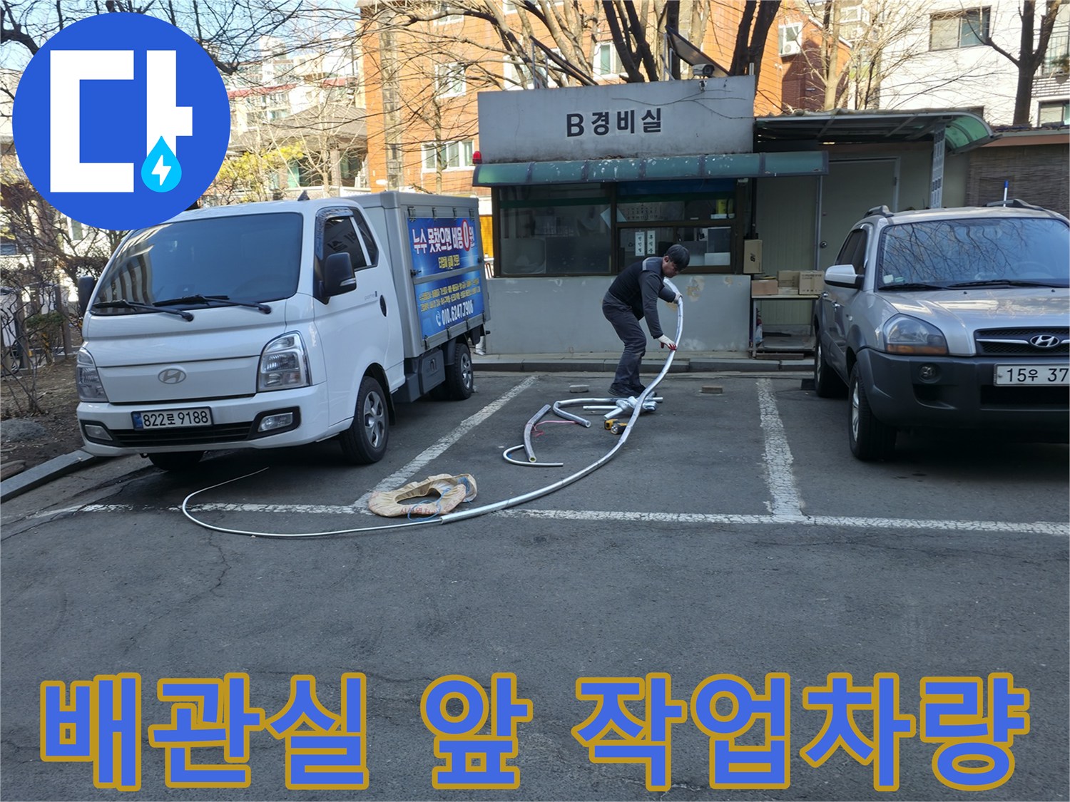 강동구 아파트 지하 배관실 앞에 주차된 작업 차량과 장비 모습
