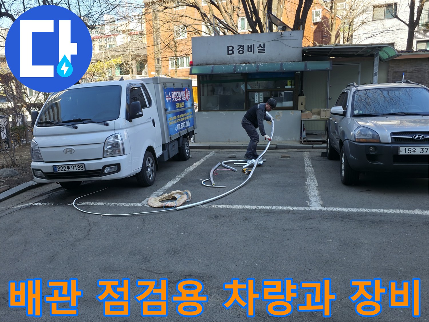 현장 작업 차량 옆으로 뻗어 있는 긴 흰색 호스 전경