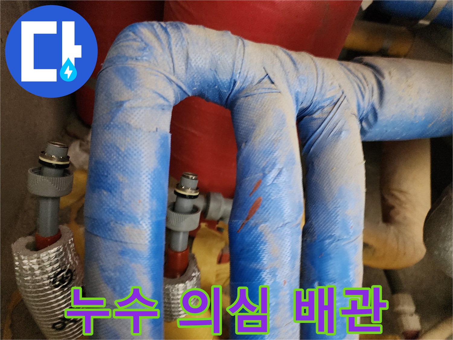 보온재가 씌워진 배관의 연결 부위 사진입니다.