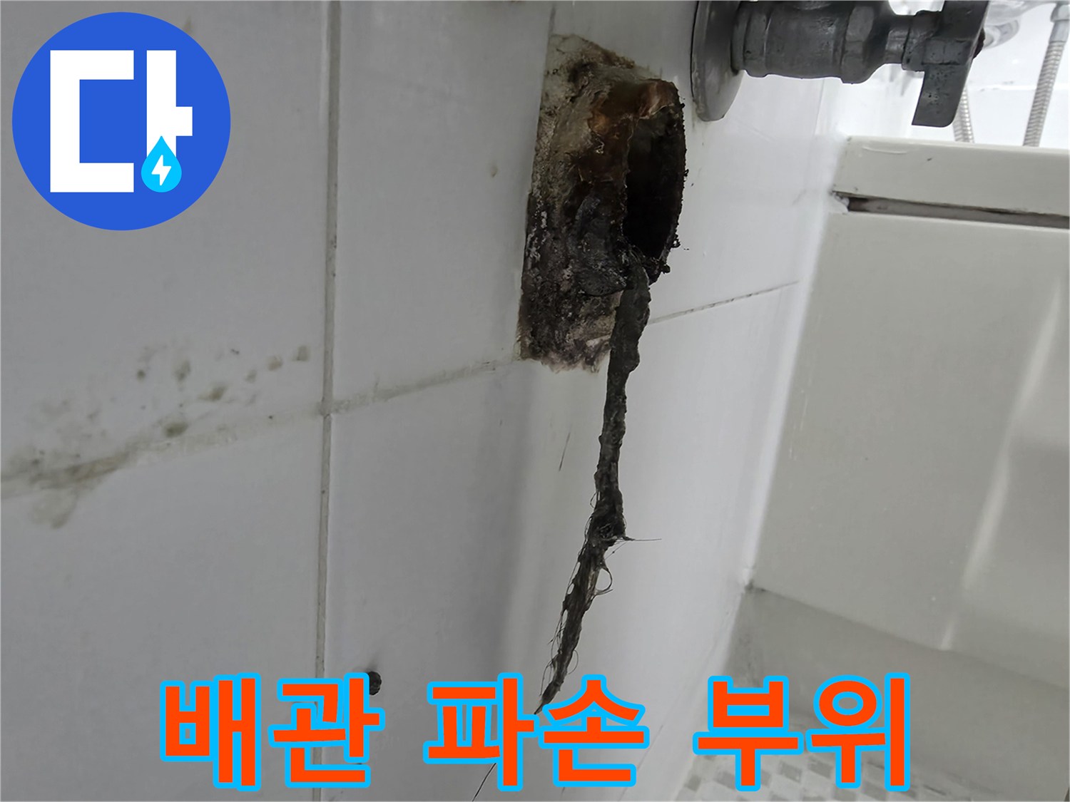 벽면 타일 사이-파손되어 노출된 배수 라인