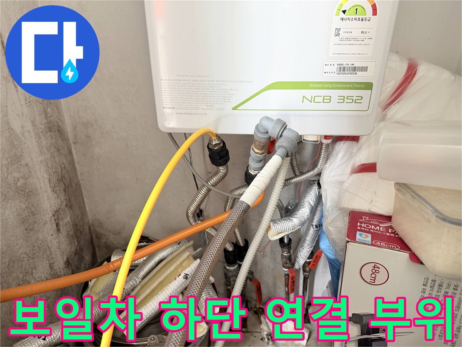 보일러 아래쪽의 은색 및 노란색 배관 구조물