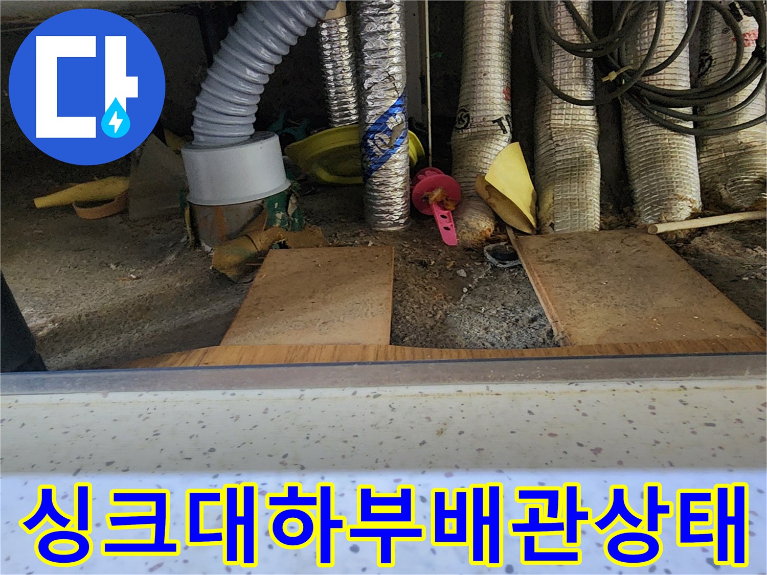 용인 수지구-싱크대 하단에 복잡하게 얽힌 배관과 분배기 모습입니다.