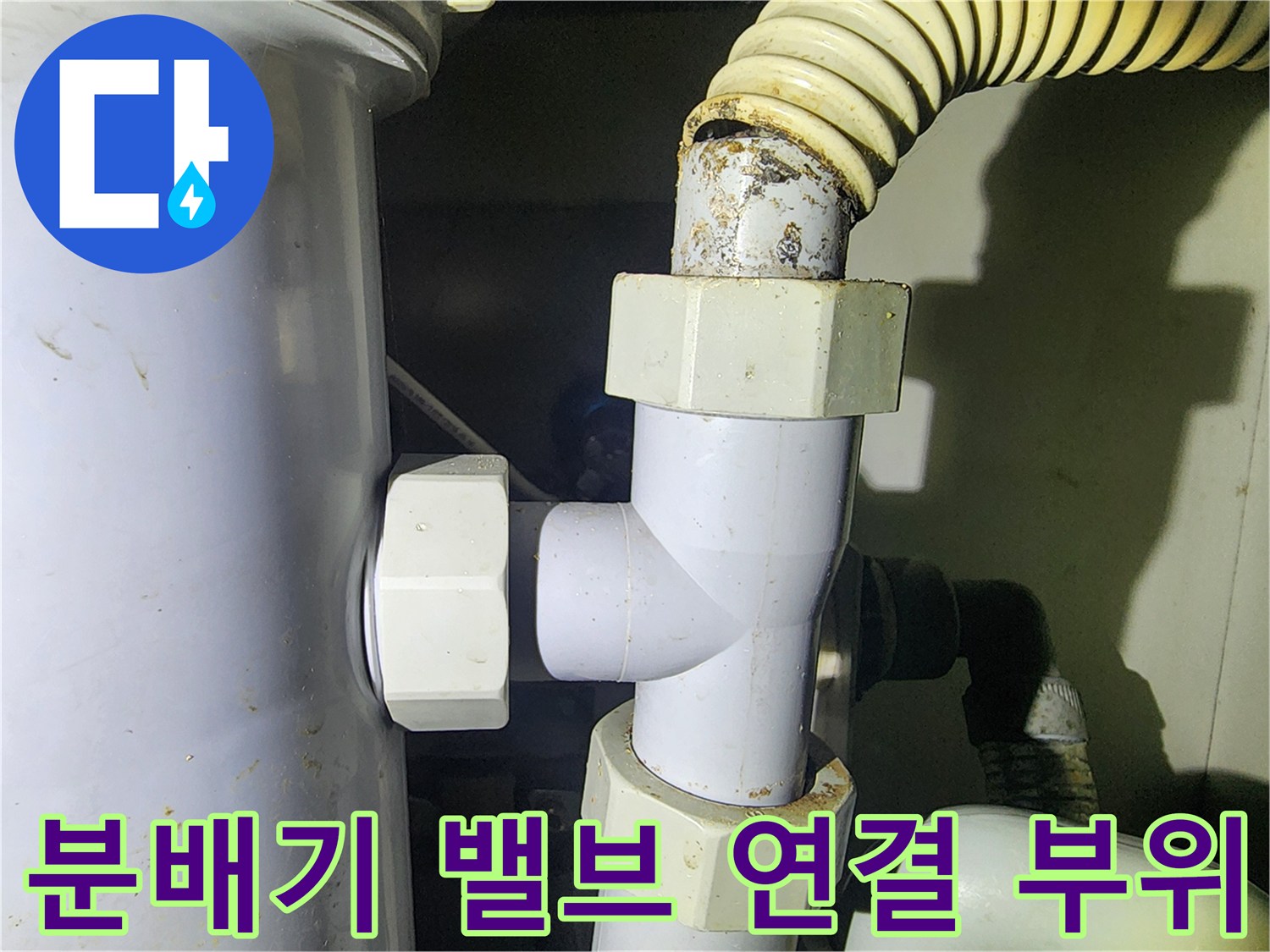 하얀색 배관 부속과 유연한 호스가 연결된 분배기 근처 모습-