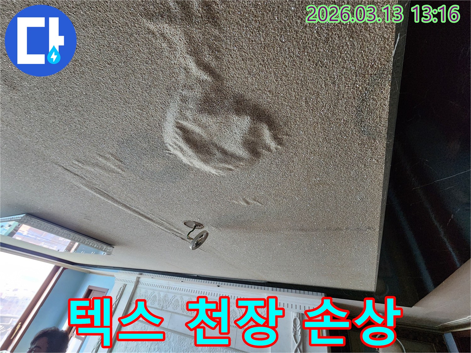 물에 젖어 형태가 변형되고 처진 텍스 재질 천장 마감재의 심각한 누수 현장