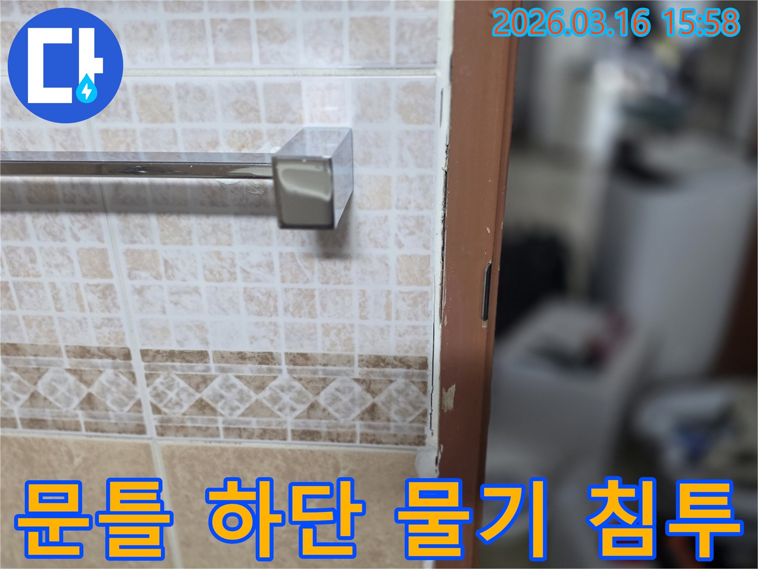 욕실 문틀 하단에-물이 침투하여-손상된-누수 현장을-촬영한-사진