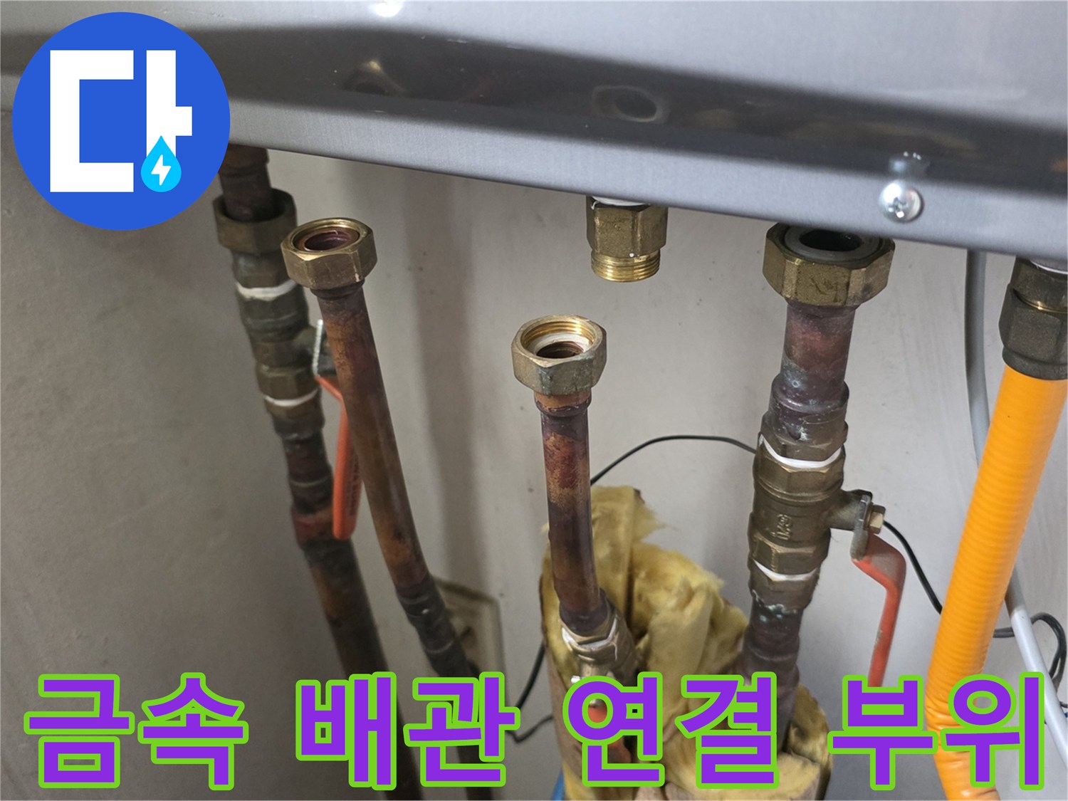 보일러 하단에 복잡하게 설치된 금속 소재의 배관들과 밸브들