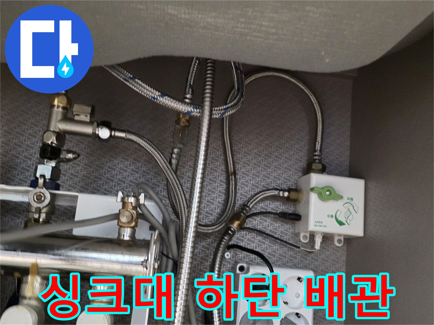 싱크대-하단에-복잡하게-연결된-금속-배관과-분배기-모습