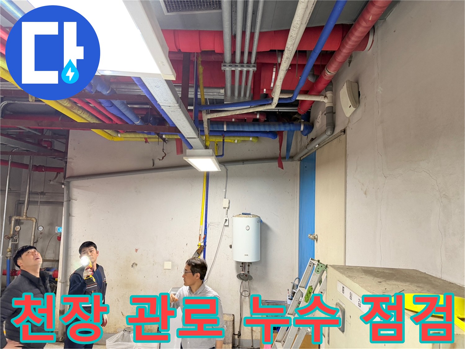 손전등을 사용하여 천장 상부의 다채로운 배관들을 조사하는 모습