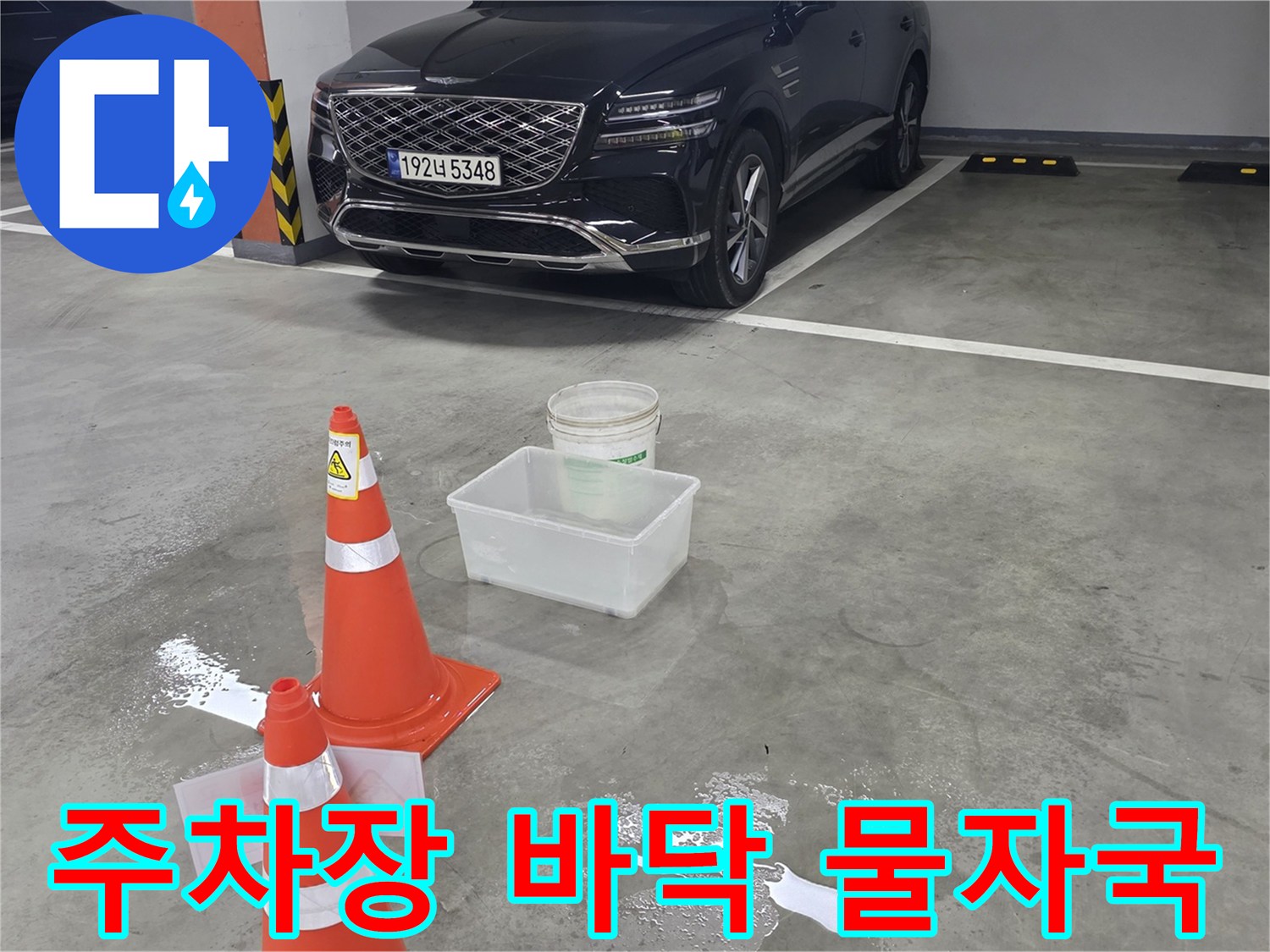 지하 주차장 바닥의 물 고임과 안전 콘 설치 현황
