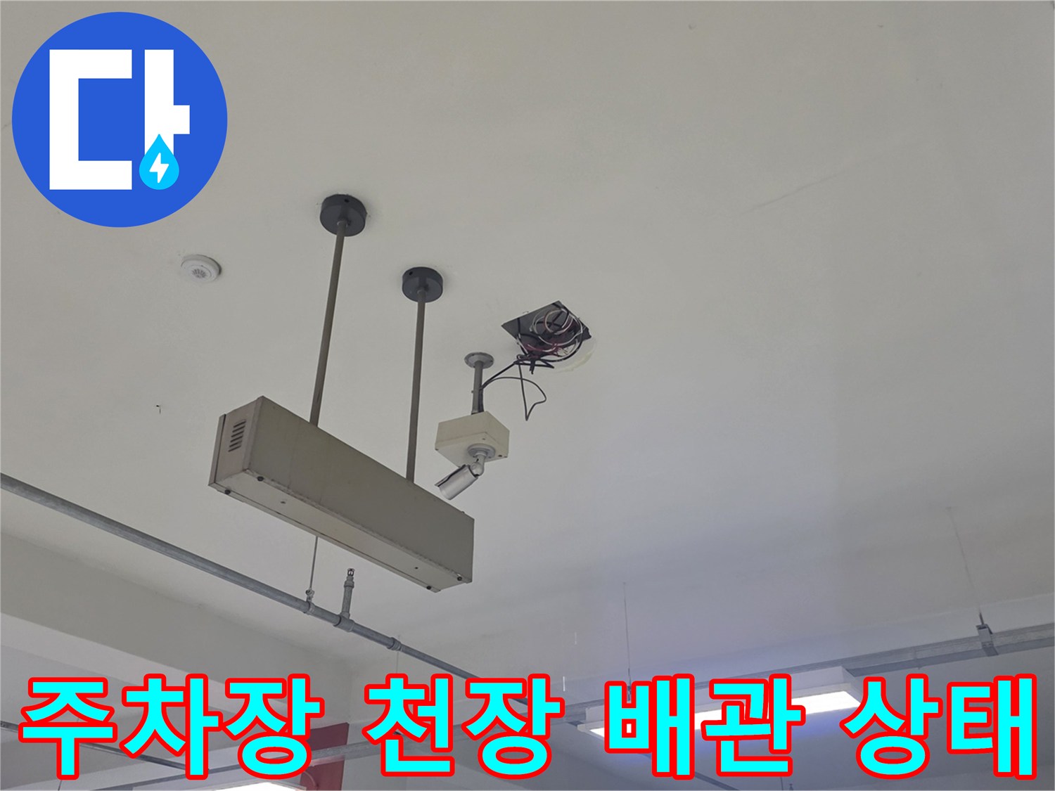 지하 주차장 천장에 설치된 배관과 조명기구의 모습입니다.