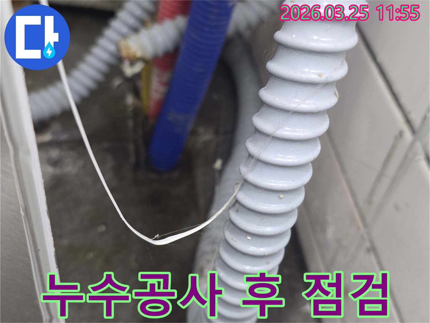 누수 공사 후-새로운 부품으로 교체되거나-보수된 배관과-주름진 호스 주변을-최종적으로 점검하는 모습