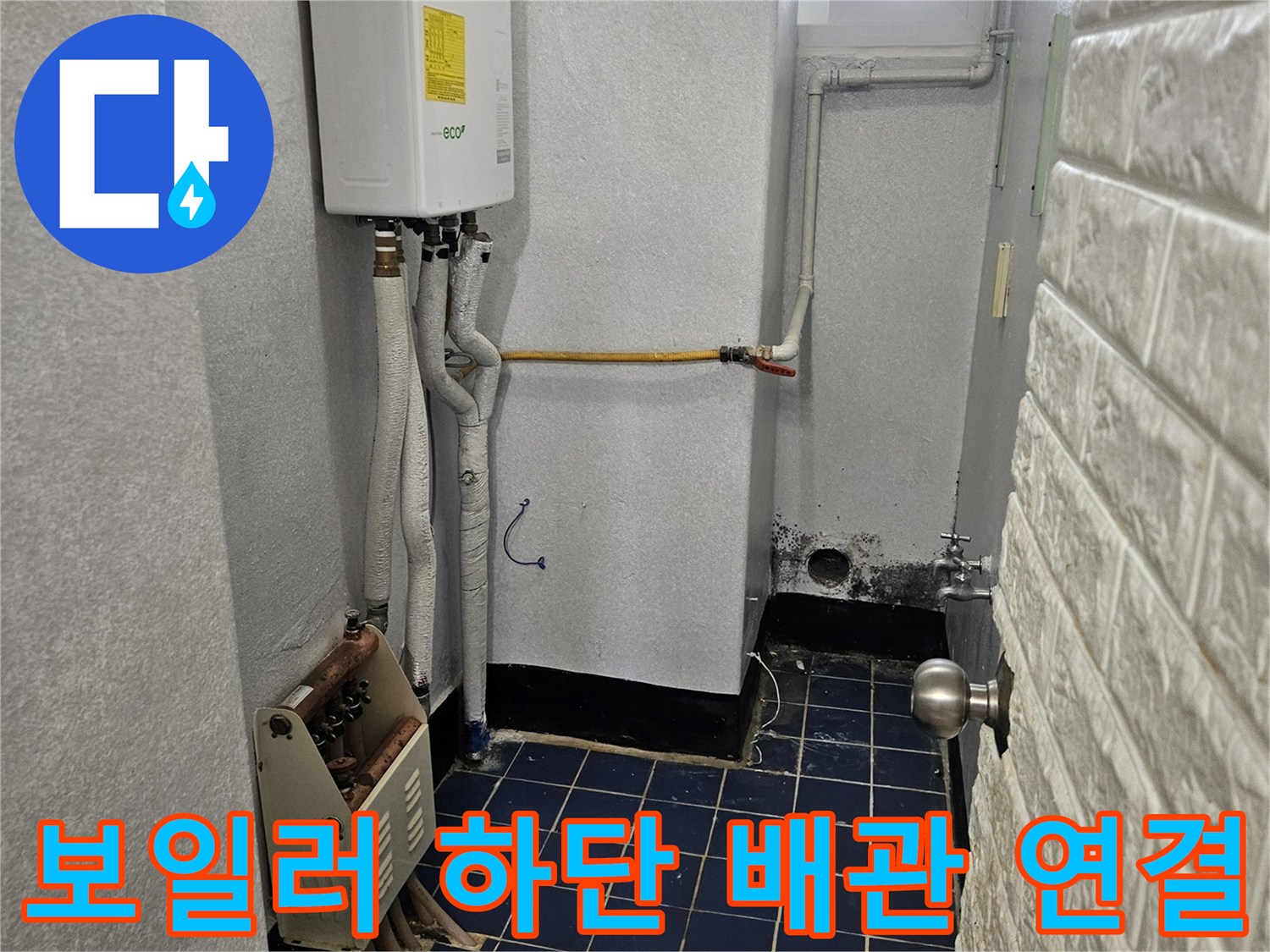 흰색 보일러와 파란 타일 벽 사이의 배관 구조