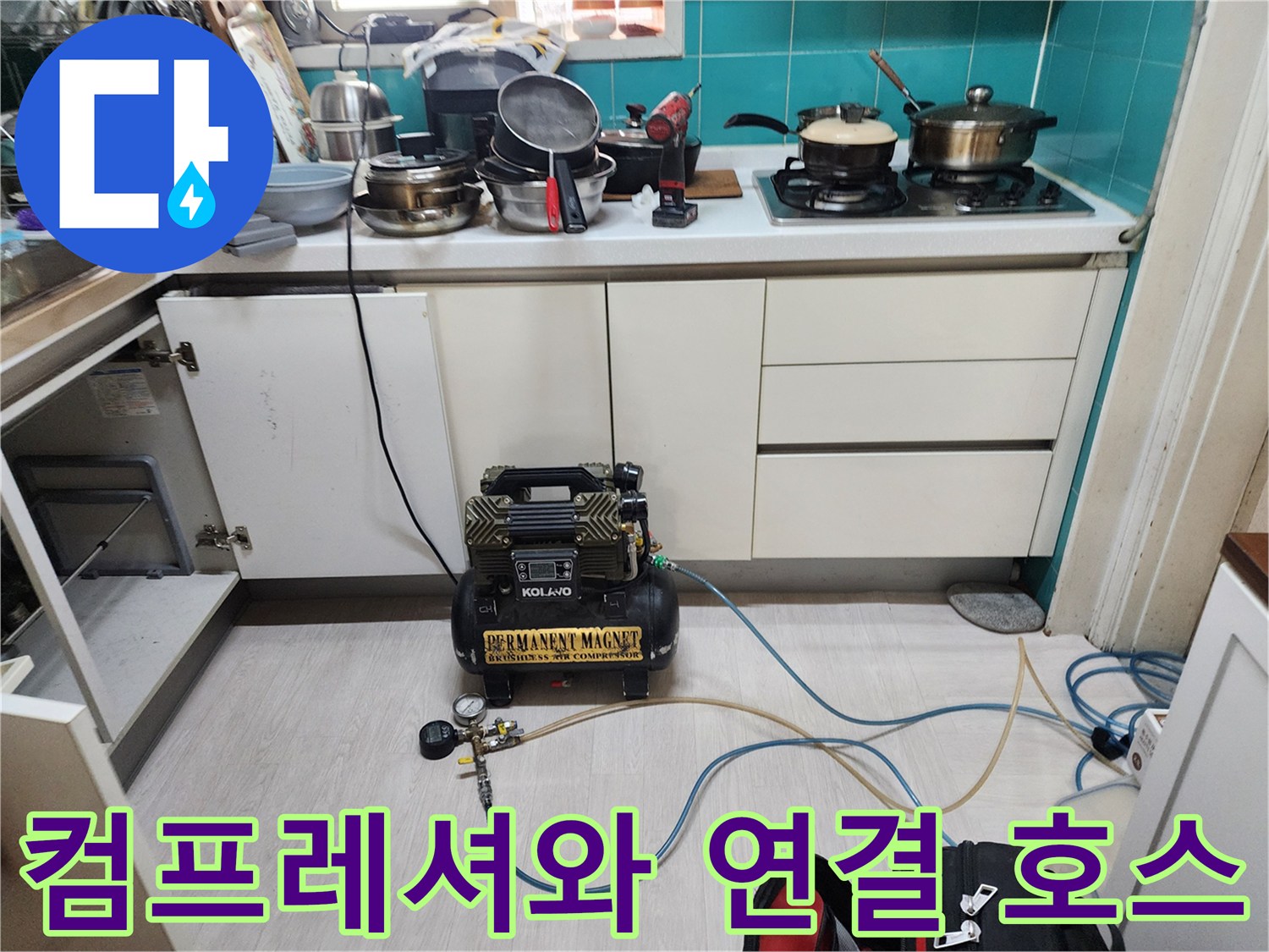 바닥에 놓인 검정색 - 컴프레셔 장비와 파란색 압력 호스