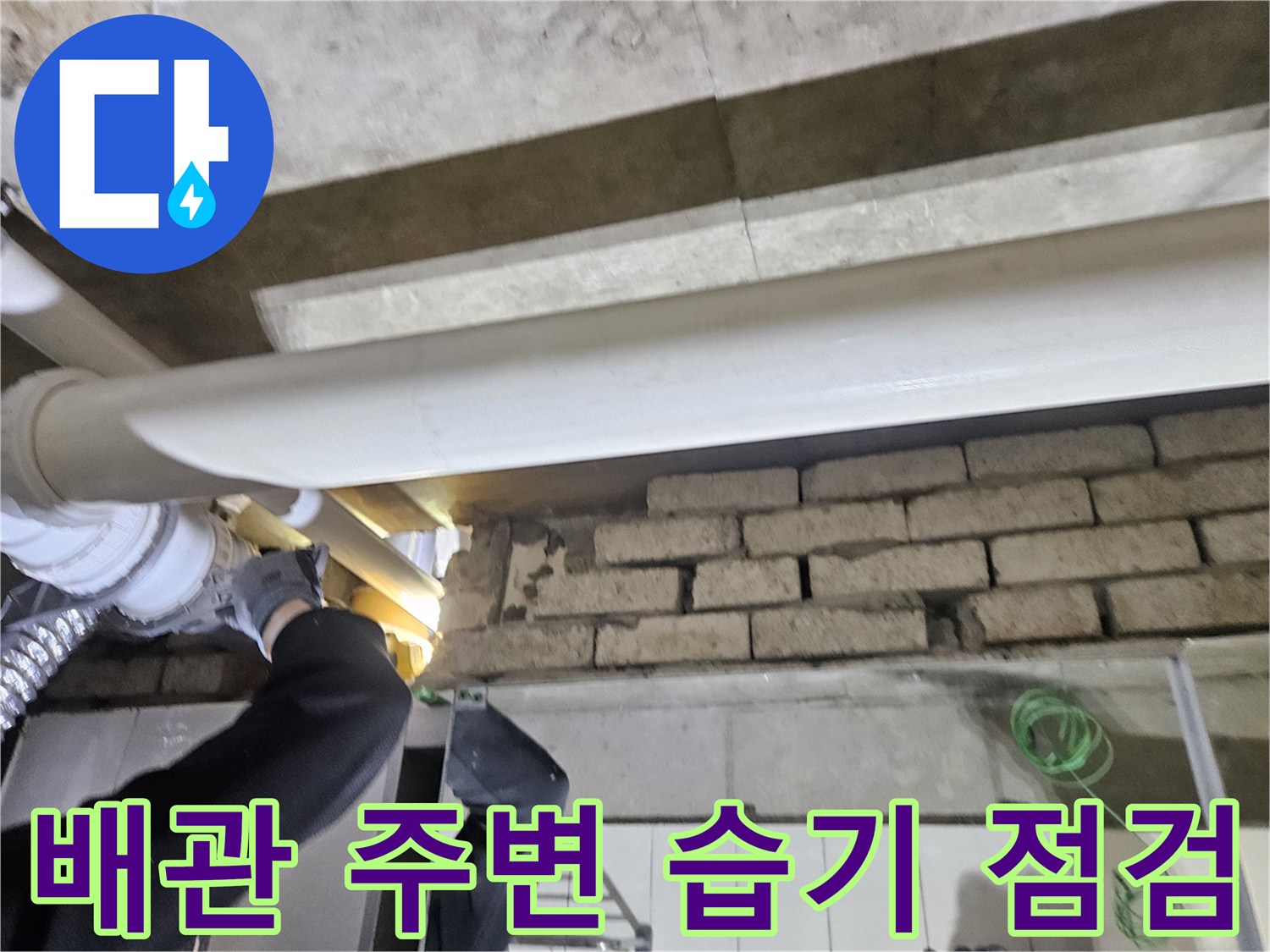 화장실 천장 내부의 하얀색 배관과 벽돌벽 구조물