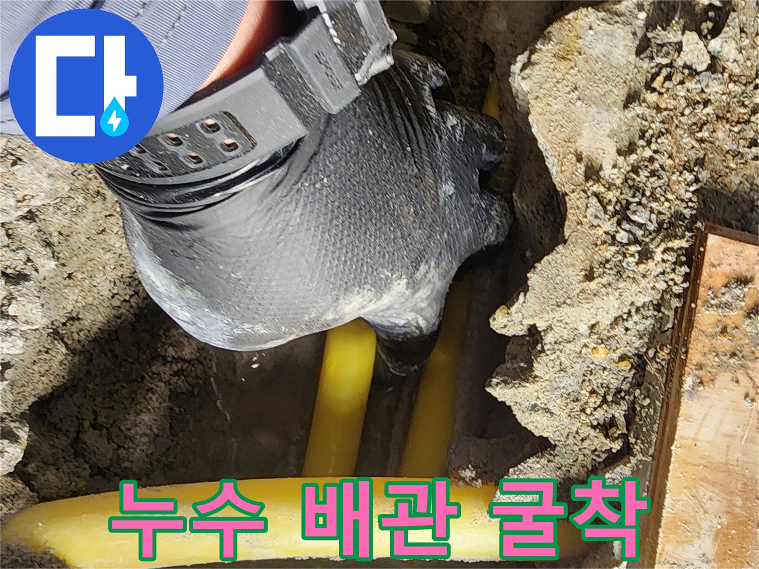 노란색 배관 주변의 젖은 흙과 콘크리트 파편