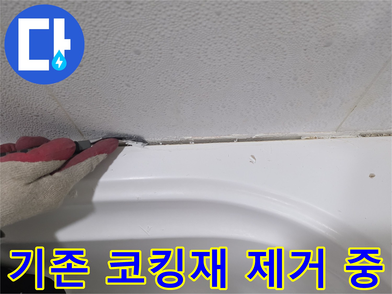 칼을 사용하여 욕조 테두리 실리콘을 떼어내는 작업자