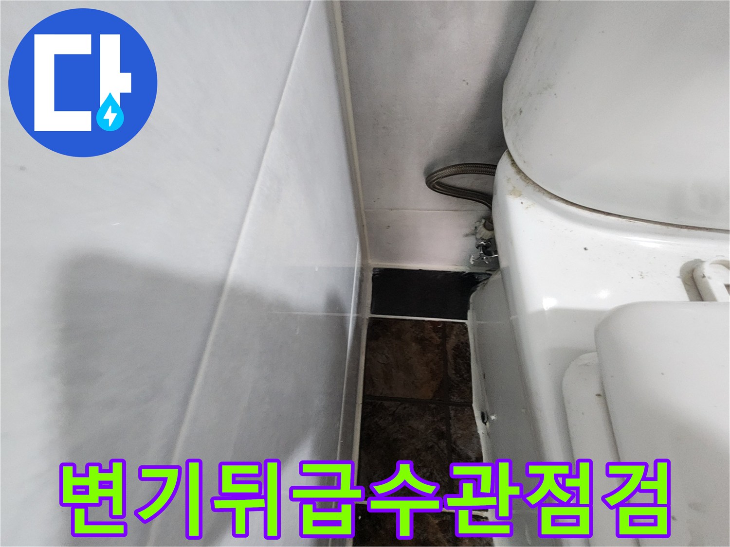 변기 뒤쪽 타일 벽면과 급수 배관의 모습