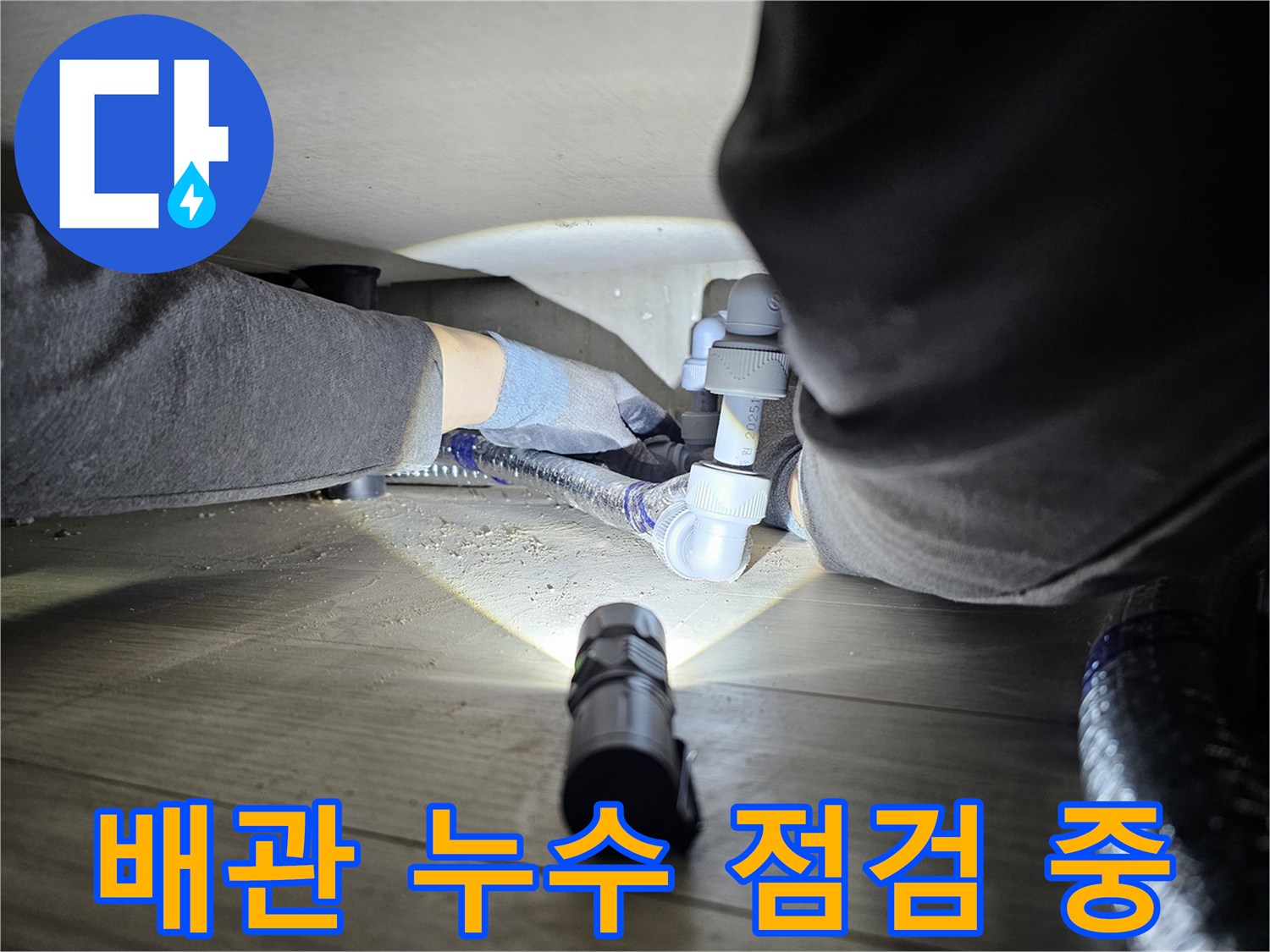 누수-탐지-전문가가-어두운-공간에서-배관-연결부를-정밀하게-점검하는-모습