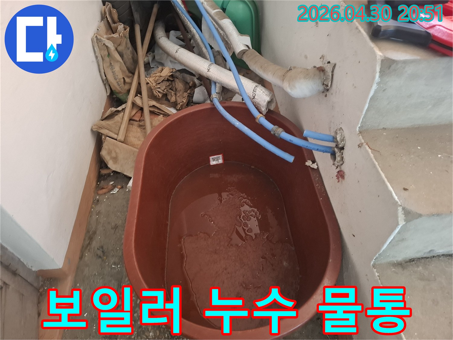 보일러 누수가-의심되는 현장에서-물이 떨어지는 것을-받아내기 위해-놓인-갈색 물통입니다