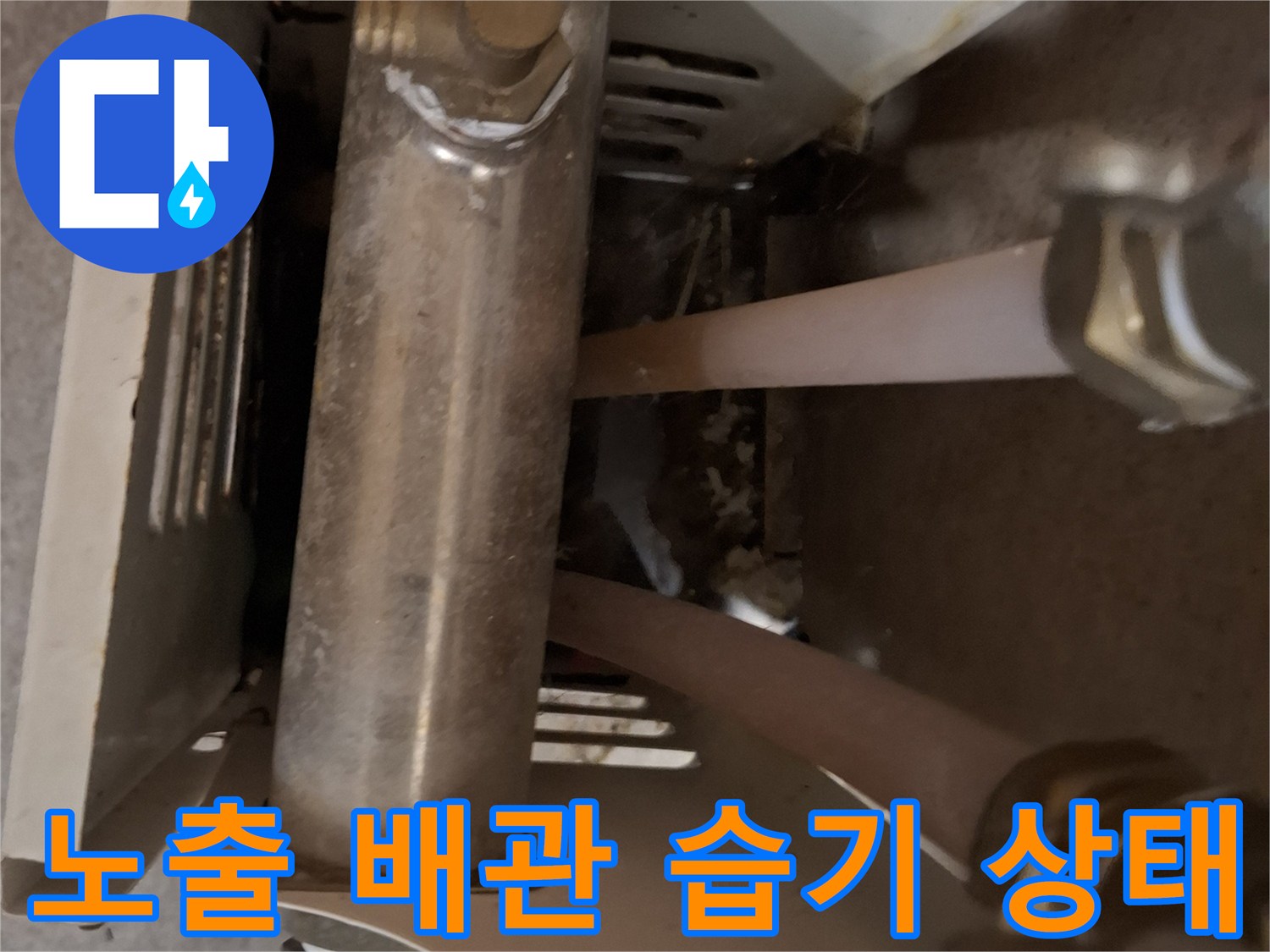 소변기 뒤편-물기가 맺힌 금속 배관 부위