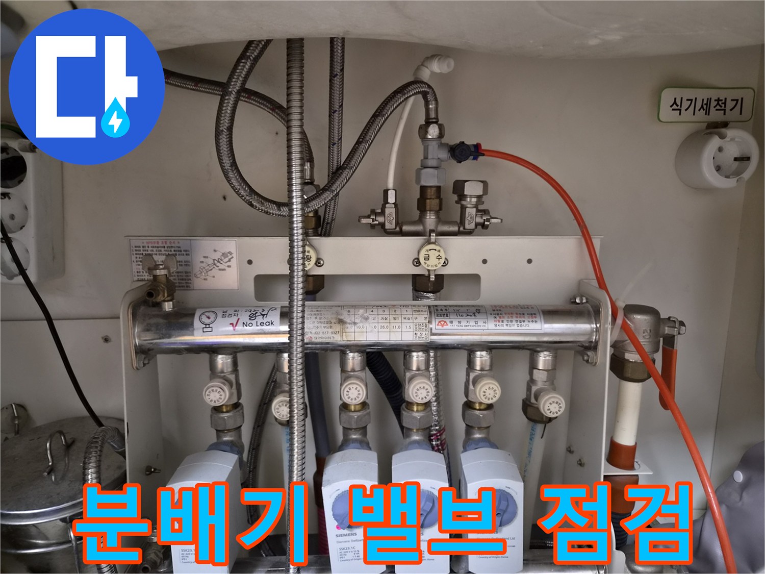 싱크대 하단에 위치한 난방 분배기와 유량계 상세 사진
