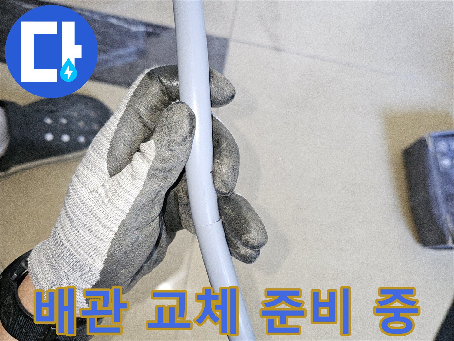 엔지니어가 손상된 회색 배관을 잡고 점검하는 현장 사진