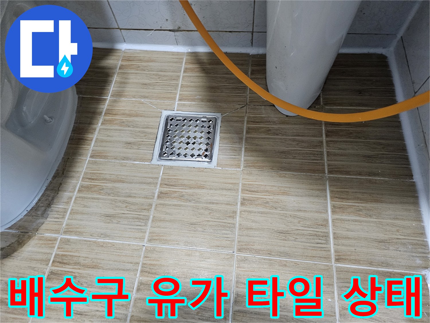 화장실 배수구 주변의 벌어진 타일 틈새 모습
