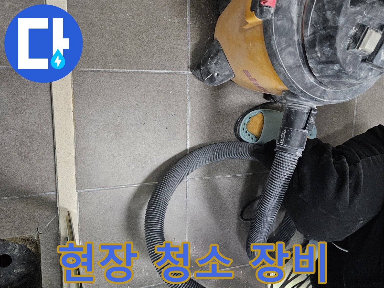 배수구 근처 타일 바닥과 작업용 진공 청소기