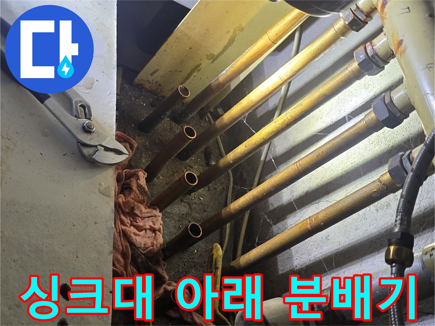싱크대 하단에 복잡하게 얽힌 보일러 분배기와 연결 배관 구조