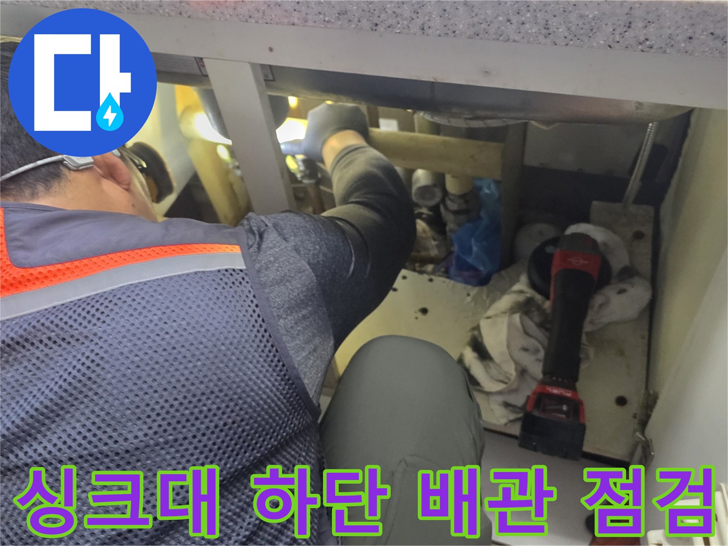 하부장 내부 분배기 주변의 누수 여부를 확인하는 모습