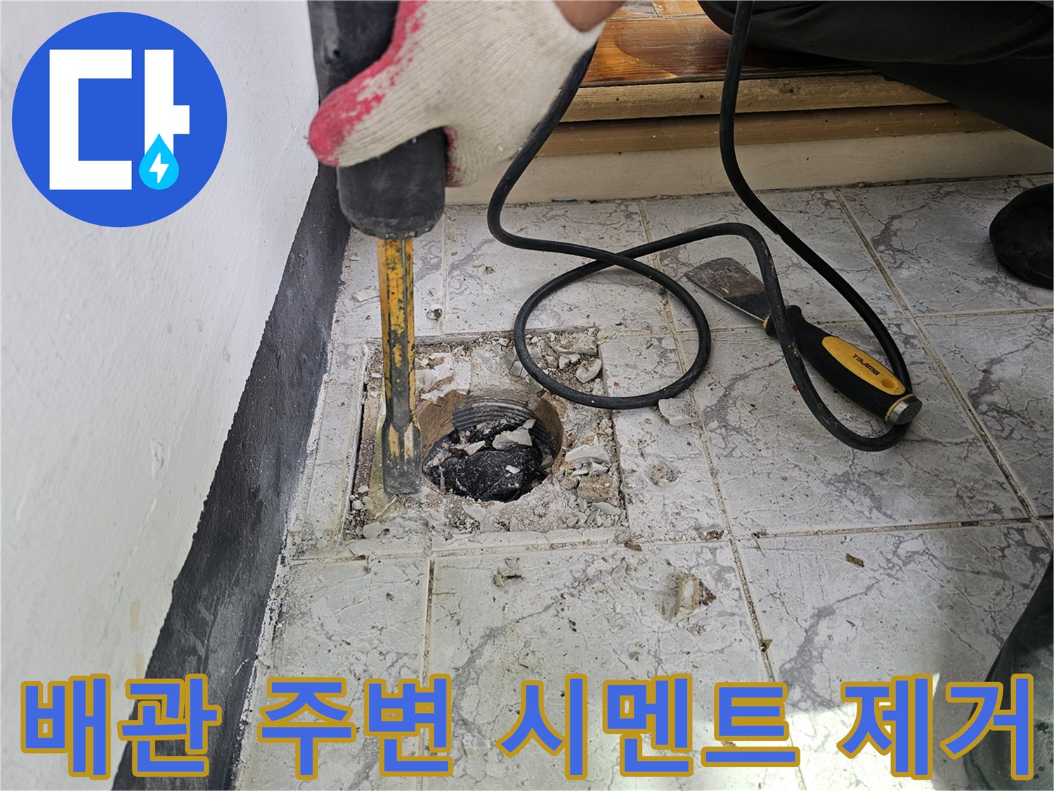 공구로 작업 중인-우수관 배관 주변의 타일 파쇄 현장 사진