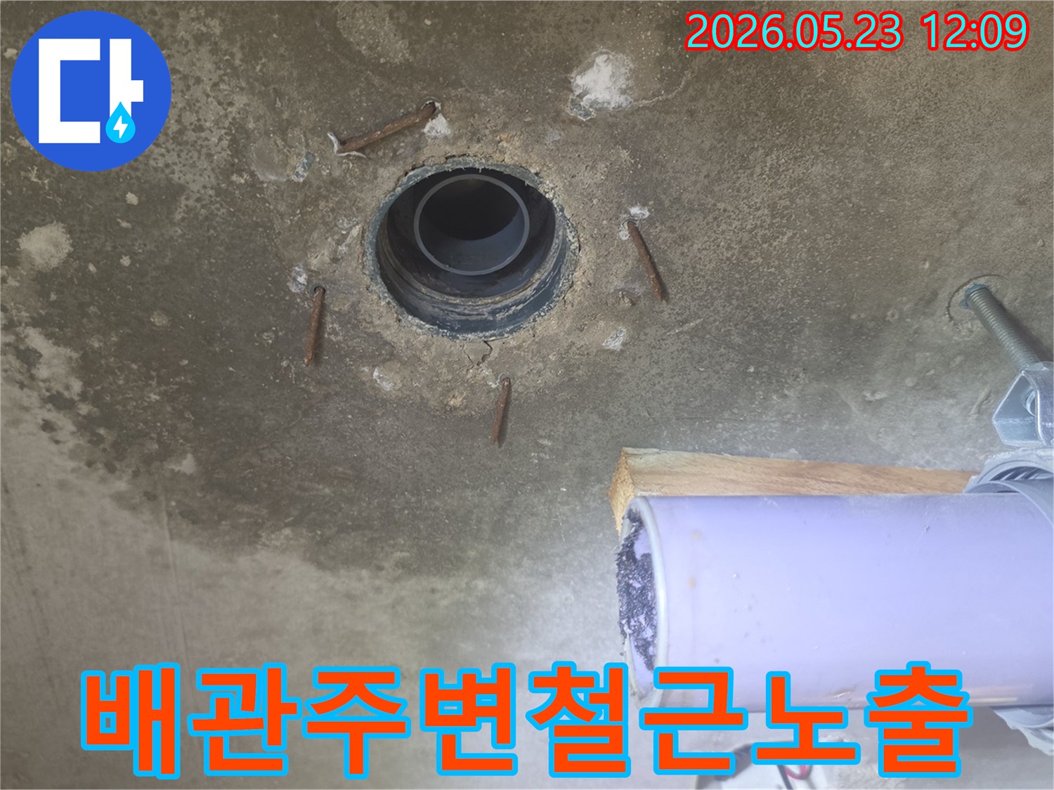 낡은 배관과-주변 콘크리트의 손상-그리고 노출된 철근을 담은 누수 공사 전 사진입니다.