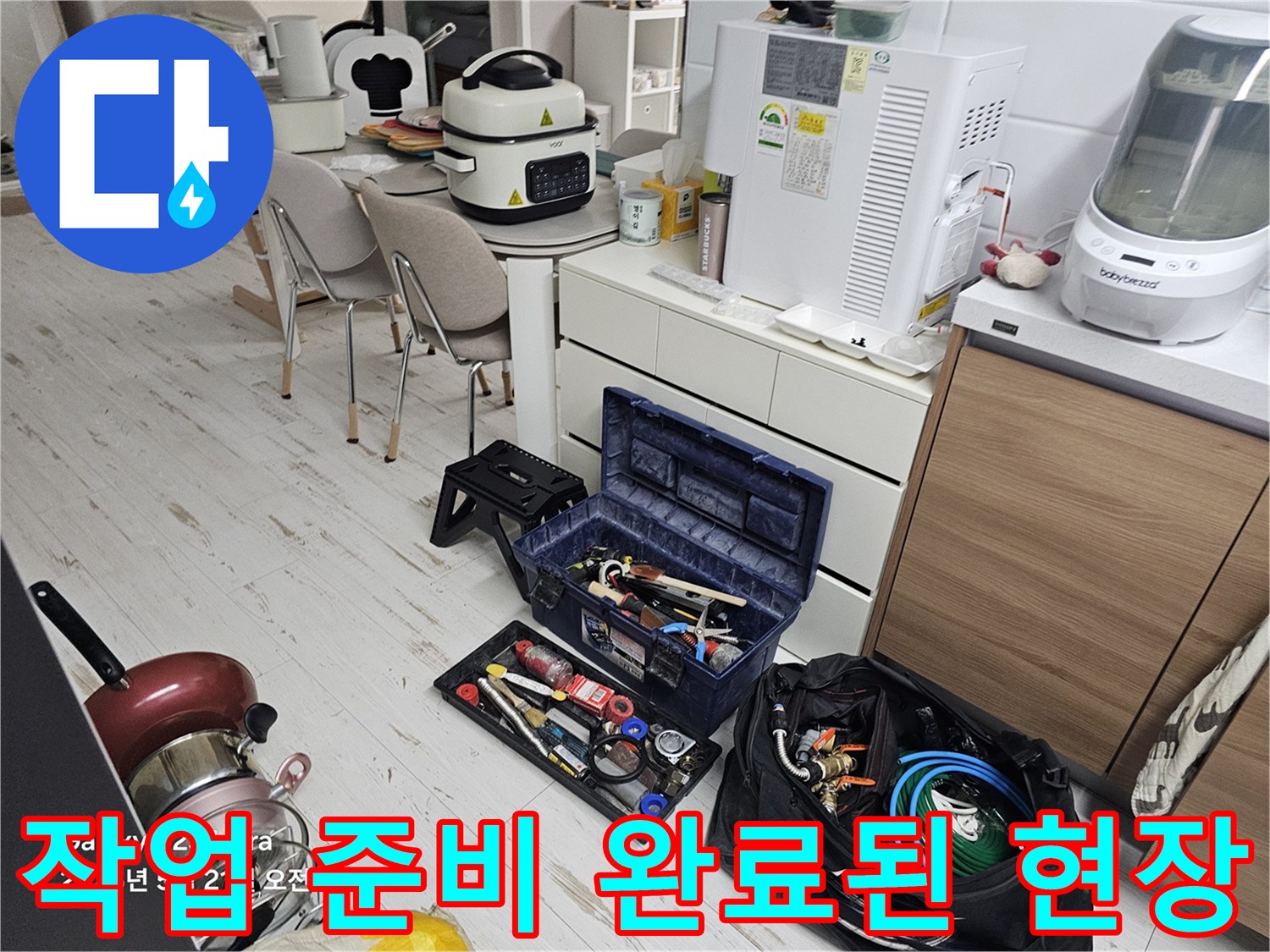 싱크대 하부 점검을 위해 정리된 작업 도구와 자재