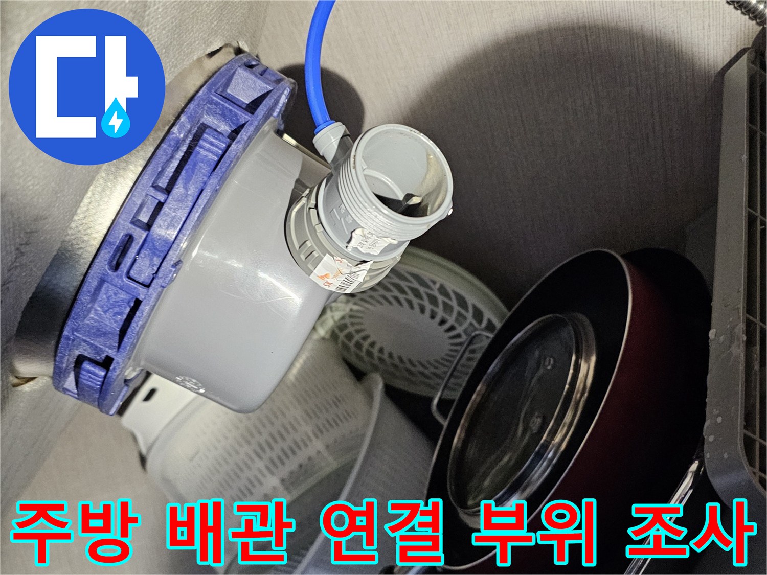 파란색 호스가 연결된 흰색 배관 부속과 주변 장비 배치 상태