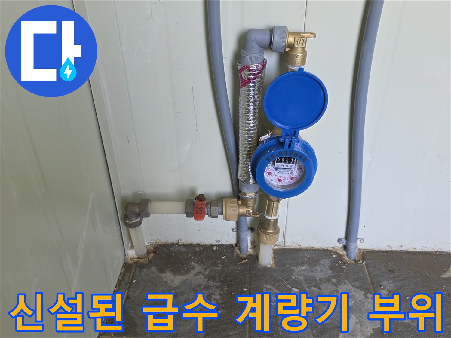 파란색 덮개가 있는 수도 계량기와 연결 배관의 상세 사진