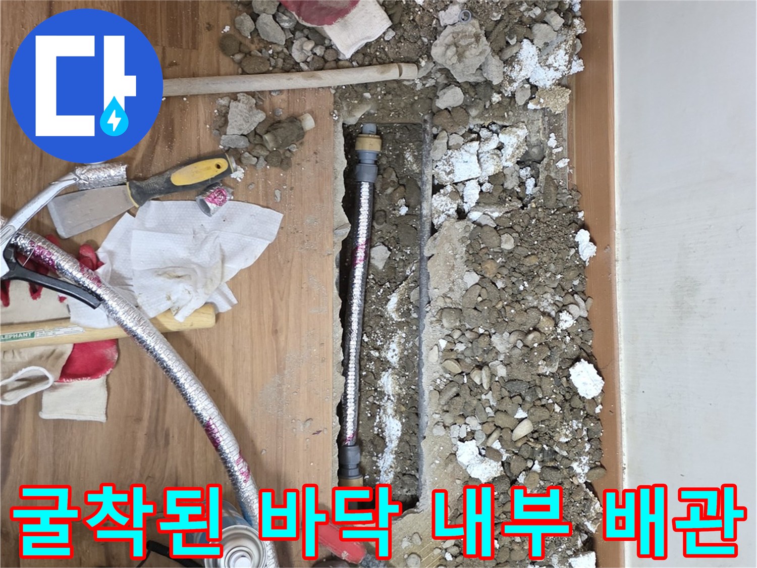 거실 마루 아래 드러난 누수 의심 배관 부위