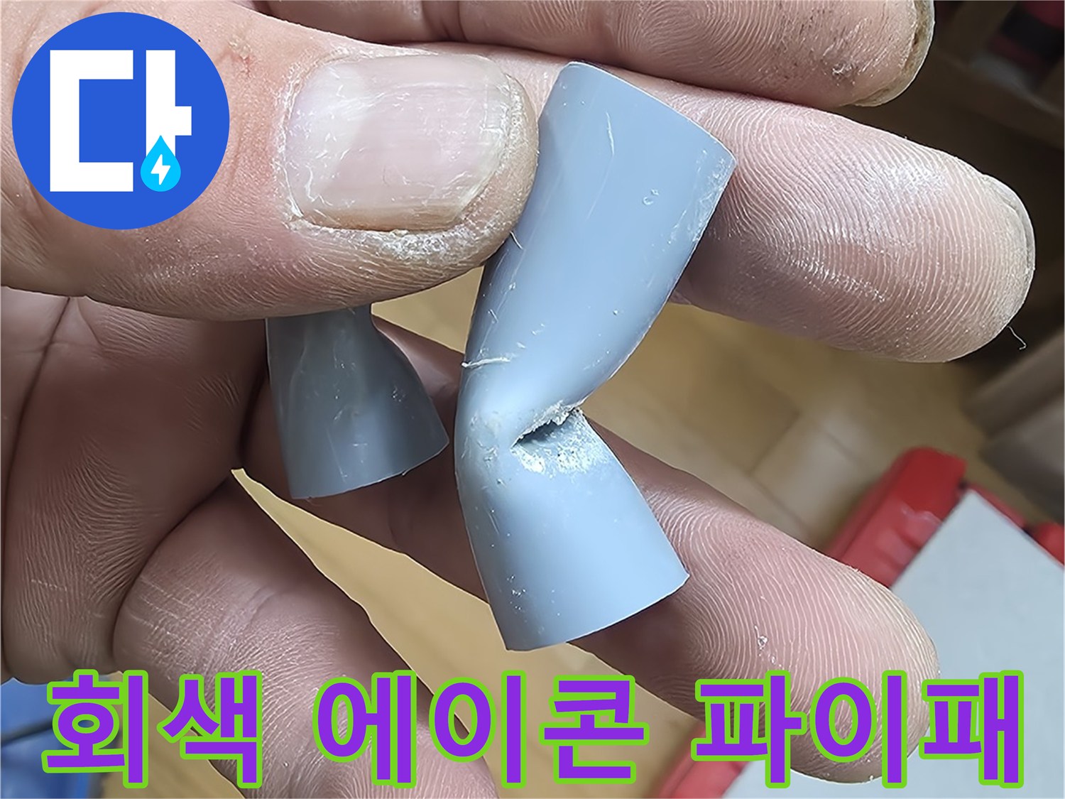 손가락으로-집어든-파손된-회색-PB배관