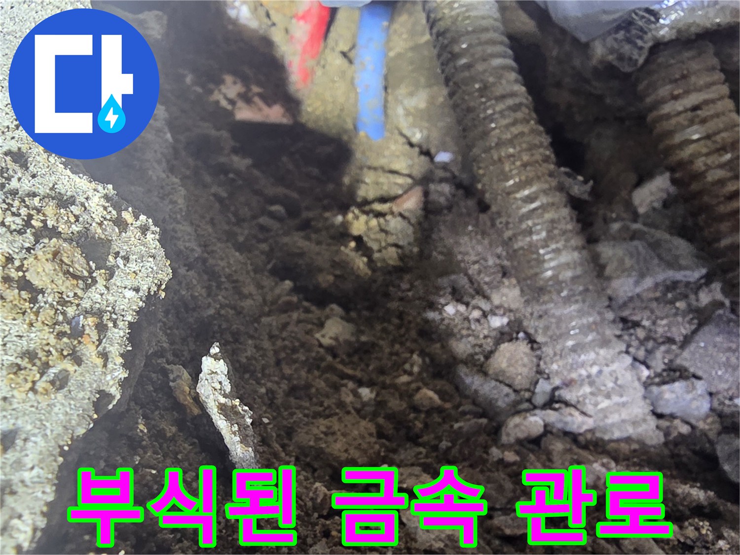 콘크리트 층 아래 노출된 부식된 배관