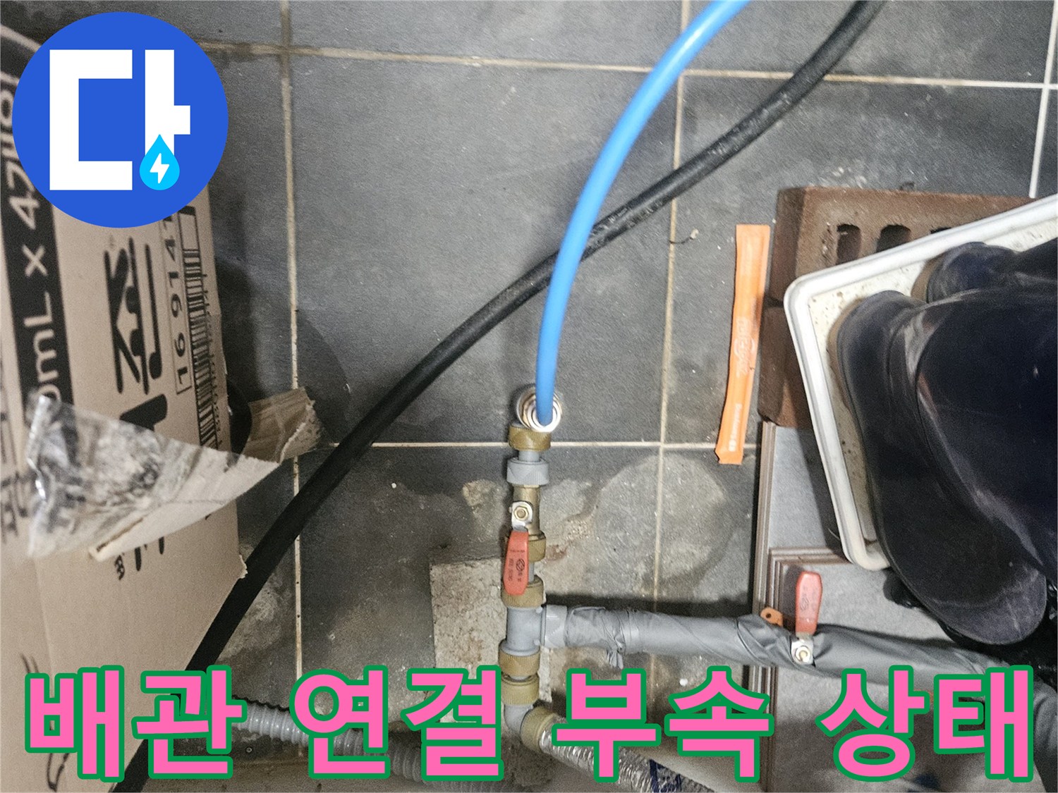 배관 연결부와 파란색 호스가 연결된 모습 - 수도 점검 중