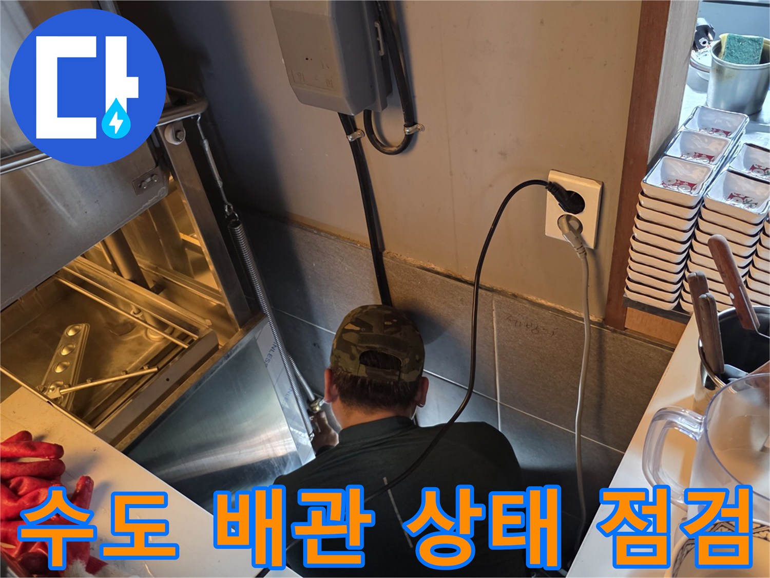 싱크대 하단 배관 구조를 면밀하게 관찰하는 작업자