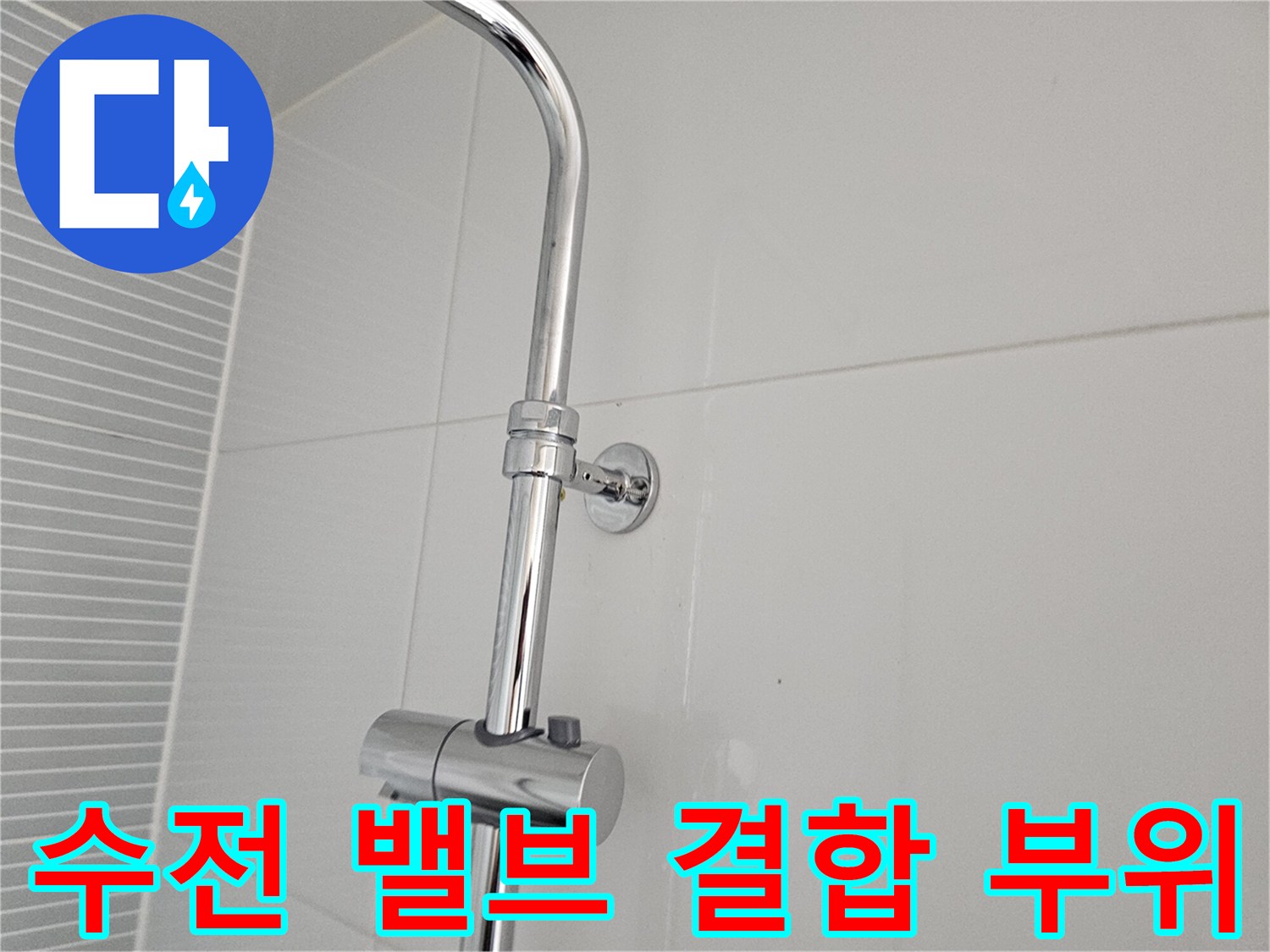 타일 벽면에 설치된 수전 조절 밸브와 배관 연결부